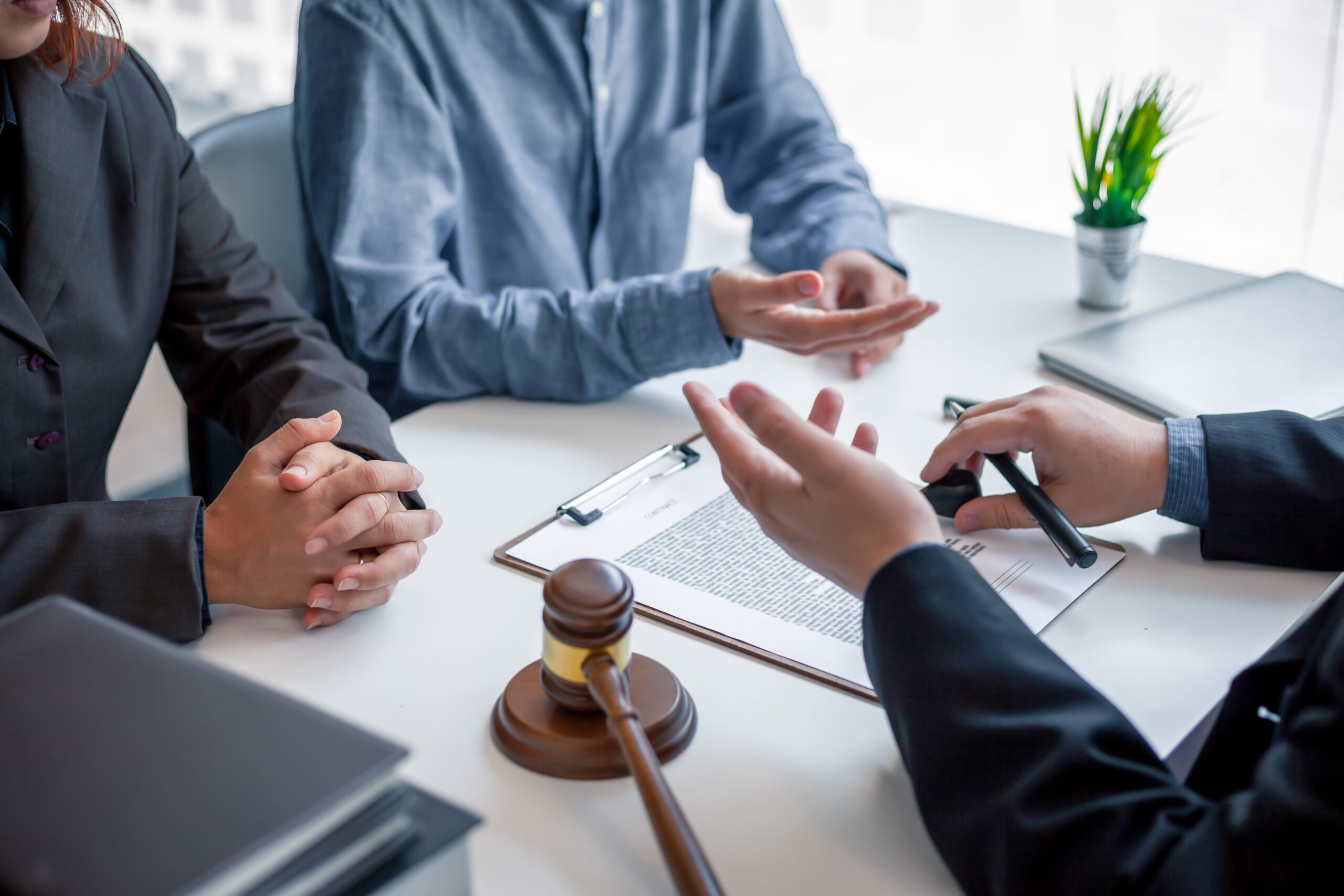 People discussing legal matters with a judge's gavel on the table.